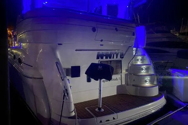 Slide: The Image of 2004 Sea Ray 390 Motor Yacht illuminated at night with blue lighting. - 36