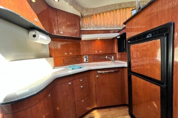 Slide: The Image of 2004 Sea Ray 390 Motor Yacht kitchen with wood cabinetry and modern appliances. - 17