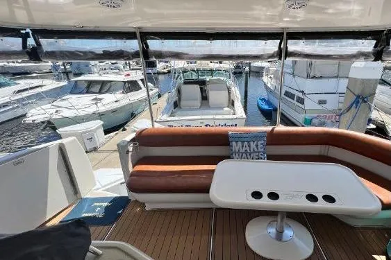 Slide: The Image of 2004 Sea Ray 390 Motor Yacht interior with seating, table, and marina view. - 14