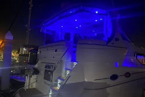 Slide: The Image of 2004 Sea Ray 390 Motor Yacht illuminated with blue lights at night. - 35