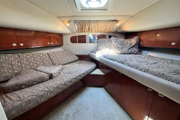 Slide: The Image of Luxurious 2004 Sea Ray 390 Motor Yacht cabin with cozy bedding and elegant wood finishes. - 24