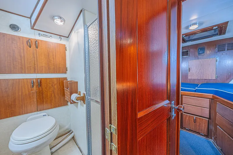 Slide: The Image of Interior of 1973 Hatteras 36 Sport Fisherman, featuring bathroom and cabin with wooden finishes. - 32