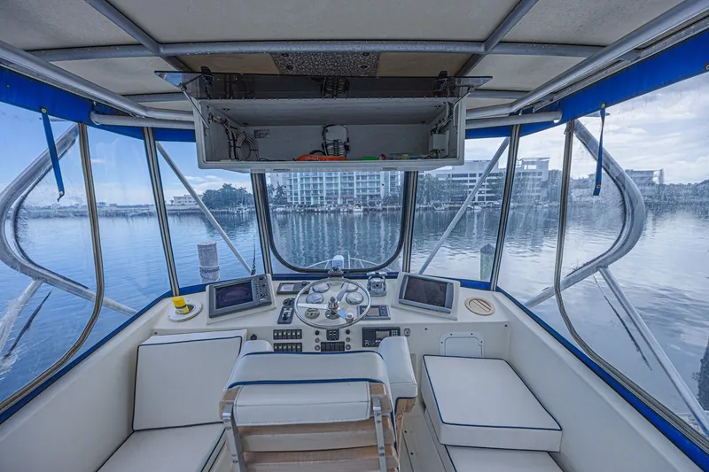 Slide: The Image of 1973 Hatteras 36 Sport Fisherman cockpit with navigation equipment and waterfront view. - 17