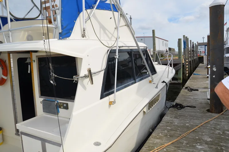 Slide: The Image of 1973 Hatteras 36 Sport Fisherman docked at a marina, showcasing classic design. - 47