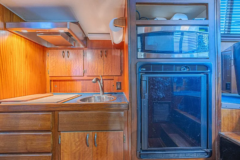 Slide: The Image of 1973 Hatteras 36 Sport Fisherman kitchen with wooden cabinets, sink, and appliances. - 29
