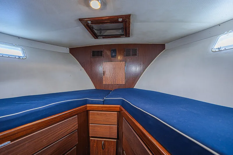 Slide: The Image of 1973 Hatteras 36 Sport Fisherman cabin interior with blue cushions and wooden cabinetry. - 36