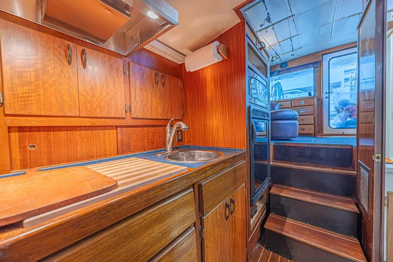 Slide: The Image of Interior of a 1973 Hatteras 36 Sport Fisherman boat with wooden cabinetry and compact kitchen. - 31