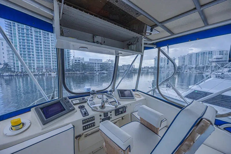 Slide: The Image of 1973 Hatteras 36 Sport Fisherman helm with marina view, featuring modern navigation equipment. - 20