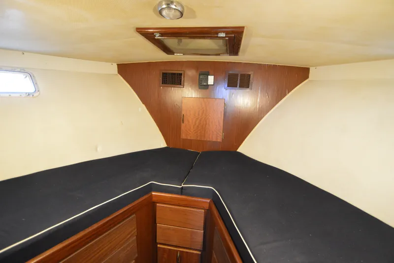 Slide: The Image of 1973 Hatteras 36 Sport Fisherman cabin interior with wood paneling and black cushions. - 37