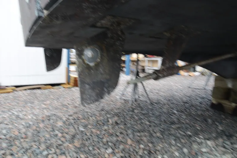 Slide: The Image of Underneath view of a 1973 Hatteras 36 Sport Fisherman boat on gravel. - 46