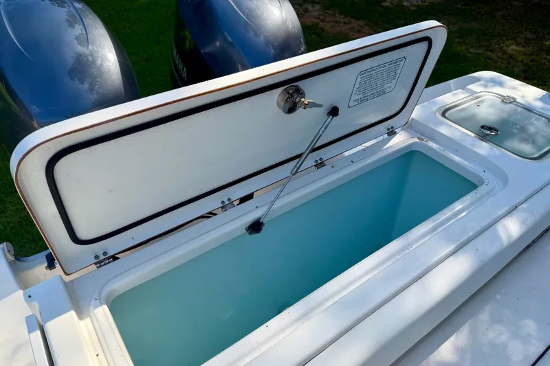 Slide: The Image of Open storage compartment on 2013 Sea Hunt Gamefish 27 boat, with dual outboard motors visible. - 14