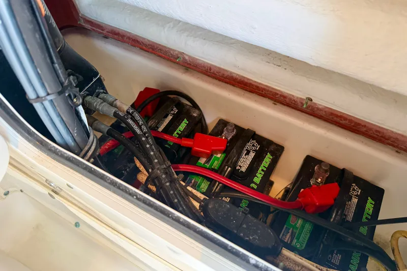 Slide: The Image of Battery compartment of a 2013 Sea Hunt Gamefish 27 boat, showing multiple batteries and cables. - 10