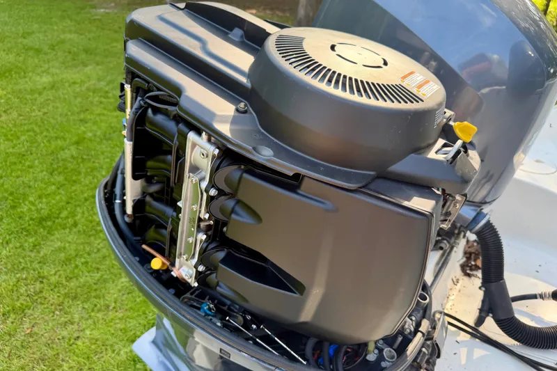 Slide: The Image of 2013 Sea Hunt Gamefish 27 outboard motor with open cover, showcasing engine components. - 15