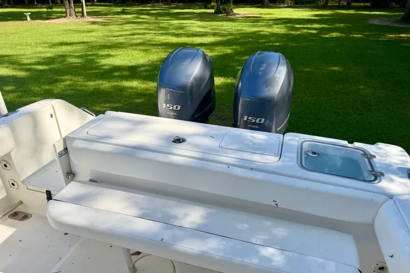 Slide: The Image of 2013 Sea Hunt Gamefish 27 boat with twin Yamaha 150 engines, parked on grass. - 6