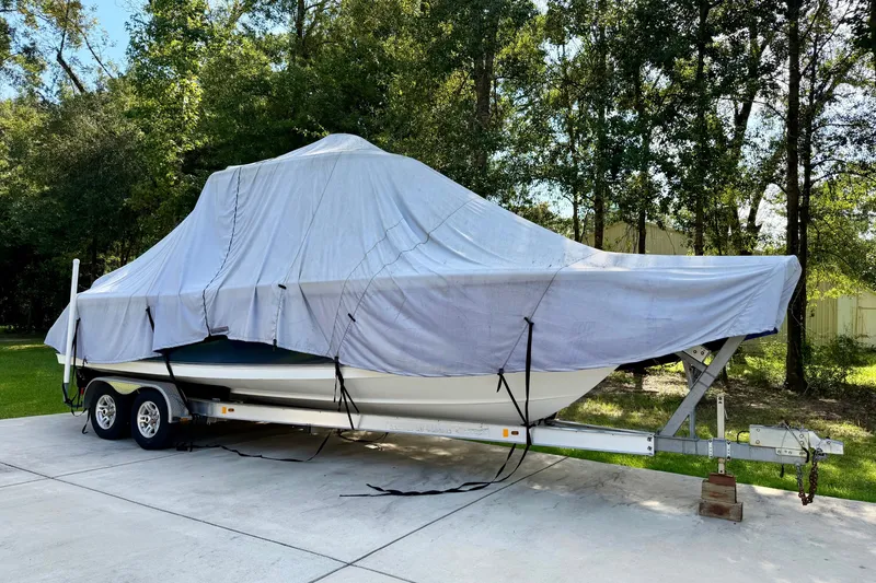 Slide: The Image of 2013 Sea Hunt Gamefish 27 boat covered on trailer, parked outdoors. - 16