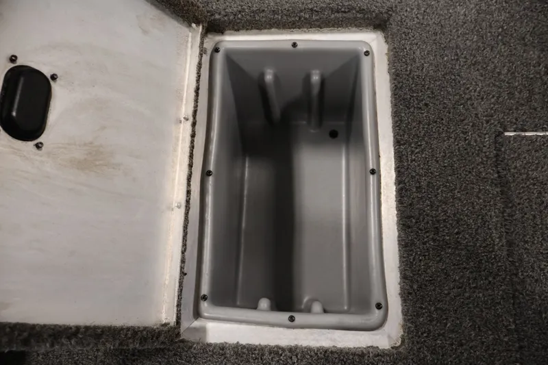 Slide: The Image of Open storage compartment in 2021 Lowe Stinger 195C boat, featuring gray interior and carpeted edges. - 33