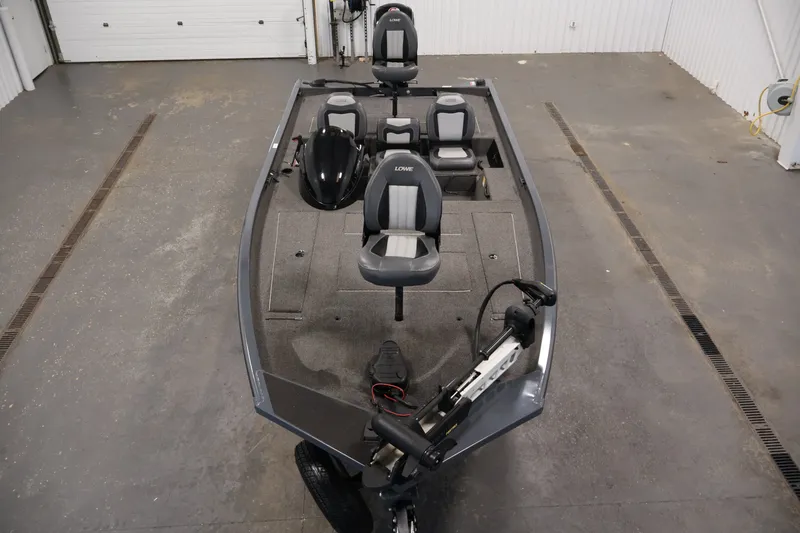 Slide: The Image of 2021 Lowe Stinger 195C fishing boat in a garage, featuring seating and equipment. - 8