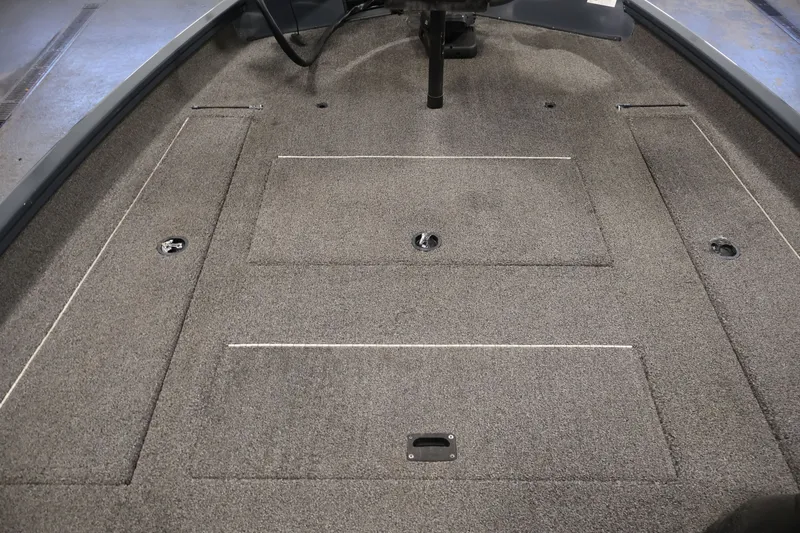 Slide: The Image of 2021 Lowe Stinger 195C boat interior with carpeted deck and storage compartments. - 15