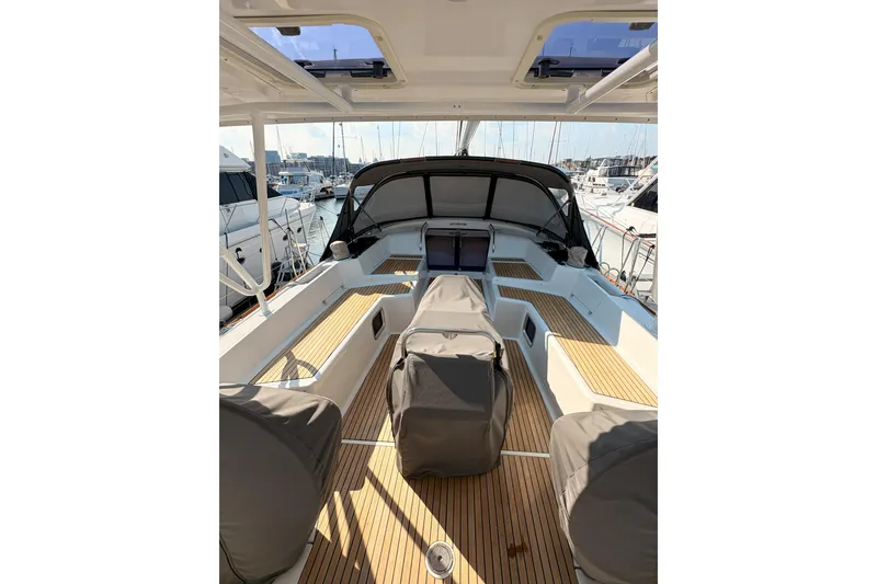 Slide: The Image of 2012 Jeanneau 57 yacht cockpit with teak flooring and covered seating at marina. - 16