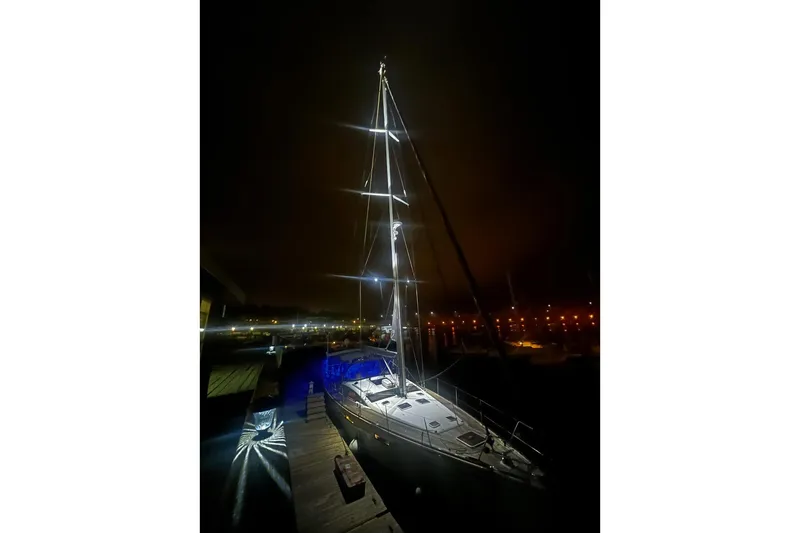 Slide: The Image of Sailboat Jeanneau 57, 2012 model, illuminated at night in a marina setting. - 25