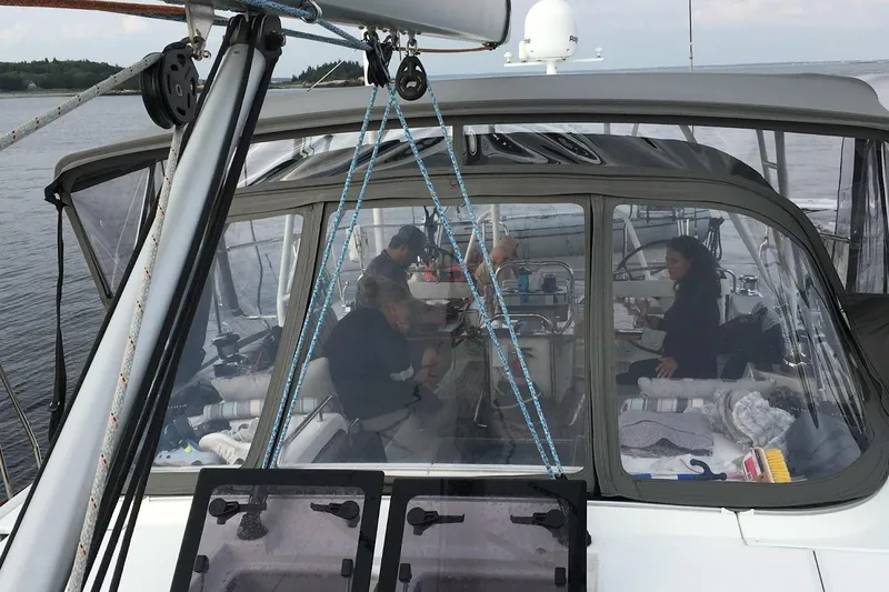 Slide: The Image of People relaxing inside a 2012 Jeanneau 57 sailboat cockpit on calm waters. - 30
