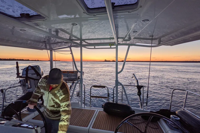 Slide: The Image of Man steering Jeanneau 57 yacht at sunset, 2012 model, on calm waters. - 28