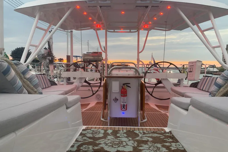 Slide: The Image of Luxurious 2012 Jeanneau 57 yacht interior with elegant seating and dual steering wheels at sunset. - 15