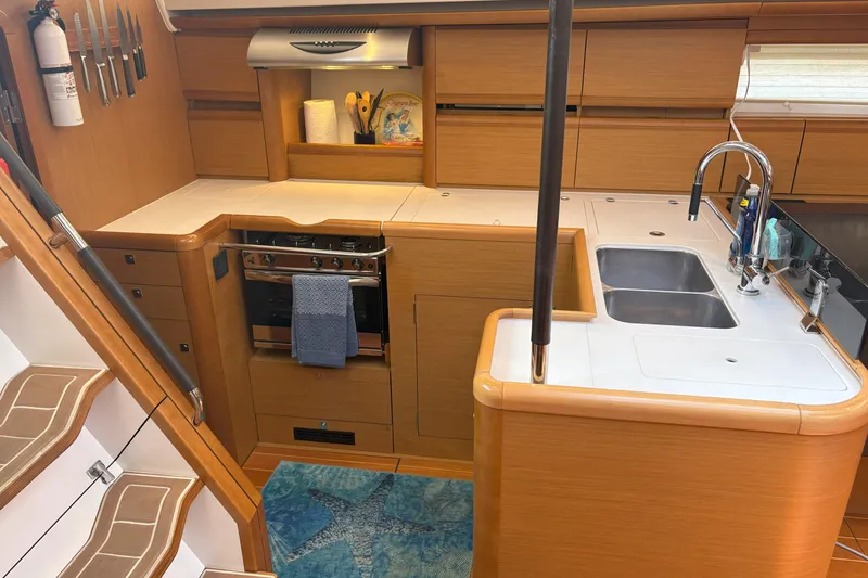 Slide: The Image of Modern kitchen interior of 2012 Jeanneau 57 yacht with wooden cabinetry and stainless steel appliances. - 49