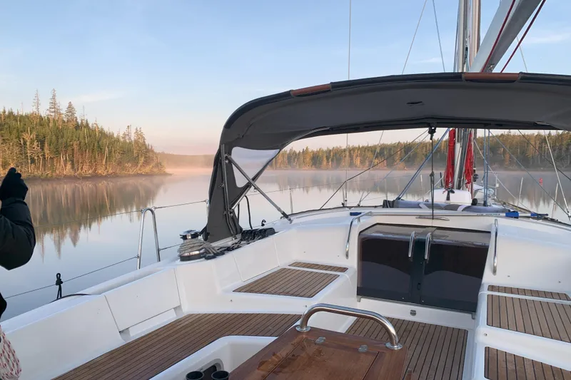 Slide: The Image of Jeanneau 57 sailboat on serene lake with misty forest backdrop, 2012 model. - 26