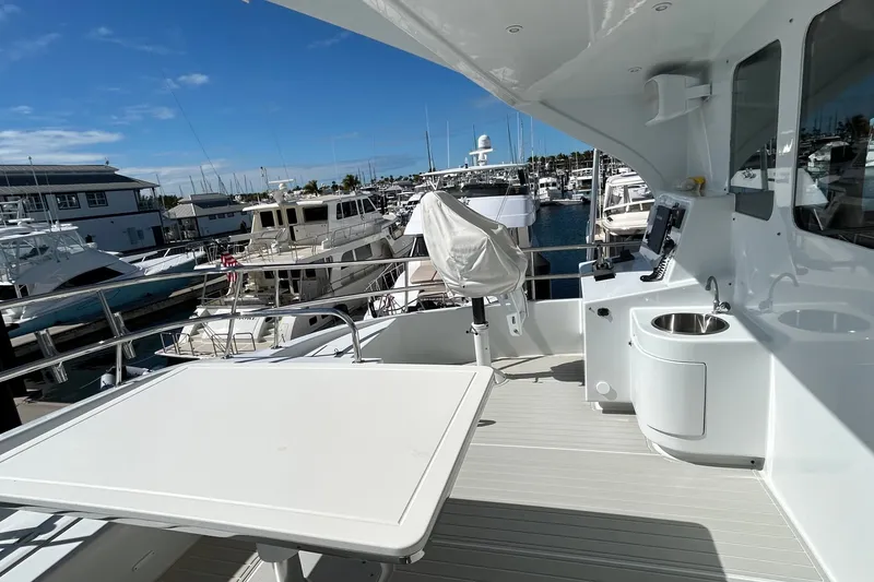 Slide: The Image of 2011 Pedigree Cat Sportfish Catamaran deck with marina view, featuring table and sink. - 8
