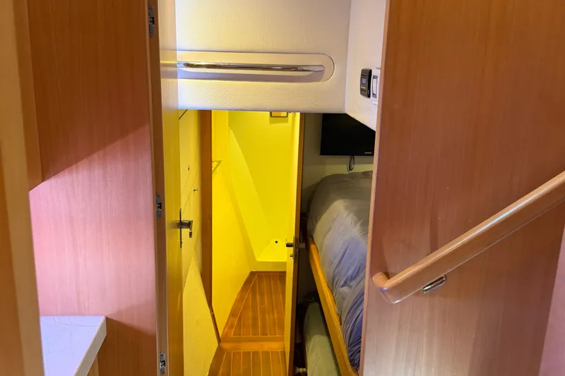 Slide: The Image of Interior view of 2011 Pedigree Cat Sportfish Catamaran, featuring wooden finishes and cozy sleeping area. - 46