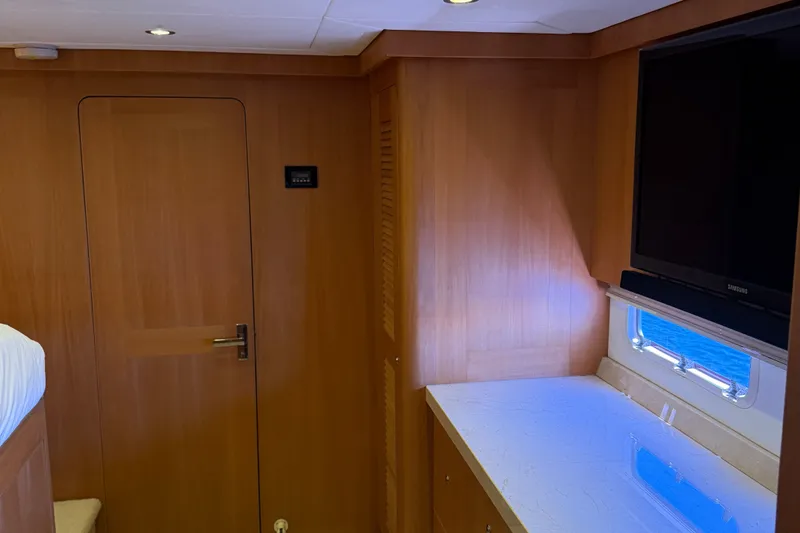 Slide: The Image of Interior of 2011 Pedigree Cat Sportfish Catamaran with wood paneling and a mounted TV. - 54