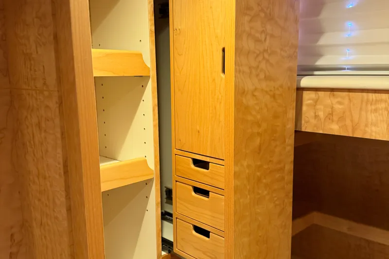 Slide: The Image of Wooden cabinetry with shelves and drawers inside a 2011 Pedigree Cat Sportfish Catamaran. - 45