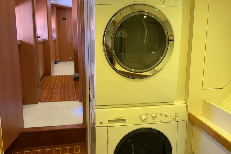 Slide: The Image of Laundry area inside 2011 Pedigree Cat Sportfish Catamaran with stacked washer and dryer. - 56