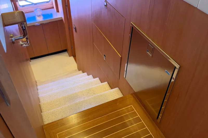 Slide: The Image of Staircase inside 2011 Pedigree Cat Sportfish Catamaran with wooden paneling and carpeted steps. - 32