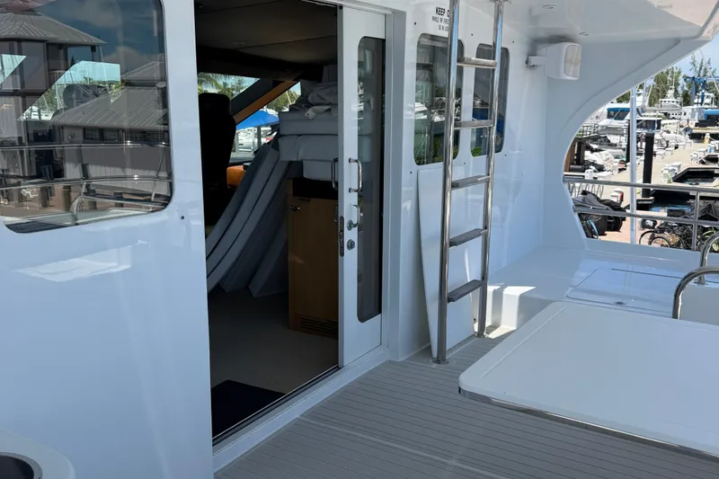 Slide: The Image of 2011 Pedigree Cat Sportfish Catamaran deck with ladder and open cabin door. - 12