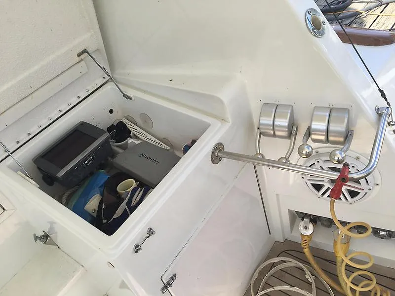 Slide: The Image of Ein offenes Staufach auf einem Boot mit verschiedenen Gegenständen, darunter ein Garmin-Gerät und Seile. - 24