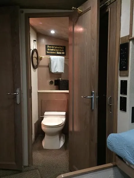 Slide: The Image of Badezimmer mit Holztüren, Toilette und Handtuchhalter in einer Hatteras 65 Convertible von 1988. - 27