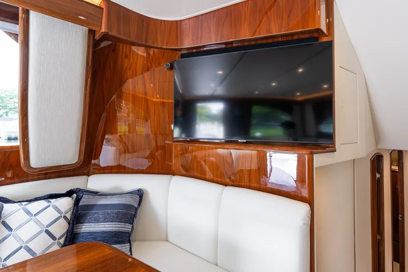 Slide: The Image of Luxurious interior of 2022 Viking 48 Convertible yacht with TV and plush seating. - 38