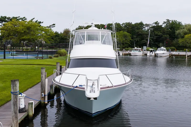 Slide: The Image of 2022 Viking 48 Convertible yacht docked in a serene marina setting. - 2