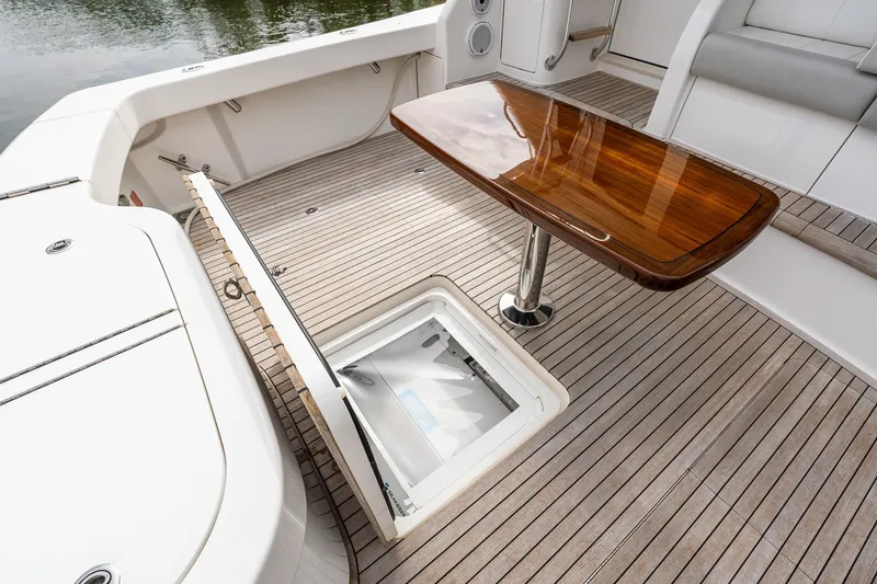 Slide: The Image of Luxury deck of 2022 Viking 48 Convertible yacht with wooden table and storage hatch. - 10