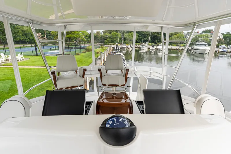 Slide: The Image of Flybridge view of 2022 Viking 48 Convertible yacht docked near tennis courts. - 20