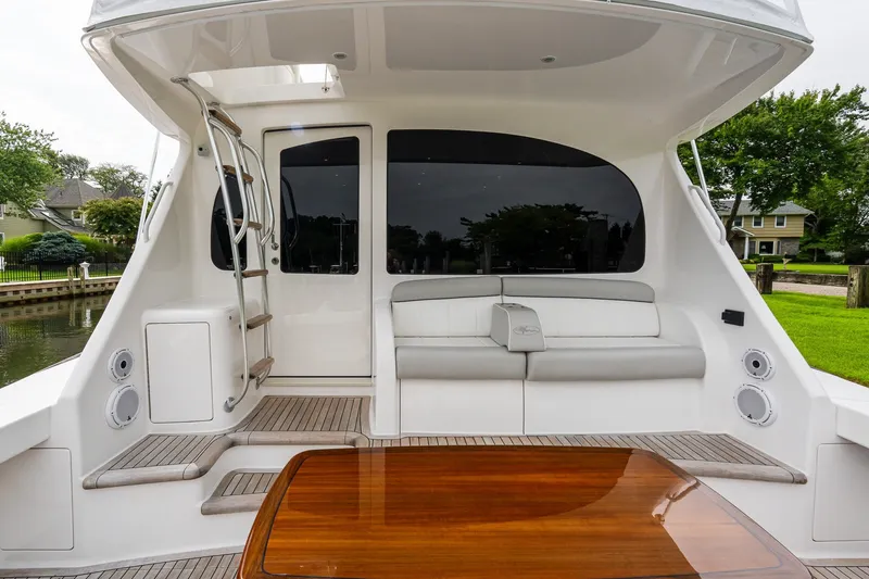 Slide: The Image of 2022 Viking 48 Convertible yacht with sleek seating and polished wood table. - 13