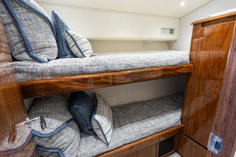 Slide: The Image of Luxurious cabin interior of 2022 Viking 48 Convertible yacht with cozy bunk beds. - 50