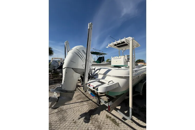 Slide: The Image of 2021 Caymas 28 HB boat with powerful outboard motor, parked on a trailer under clear blue sky. - 27