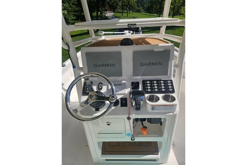 Slide: The Image of 2021 Caymas 28 HB boat dashboard with Garmin displays and steering wheel. - 2