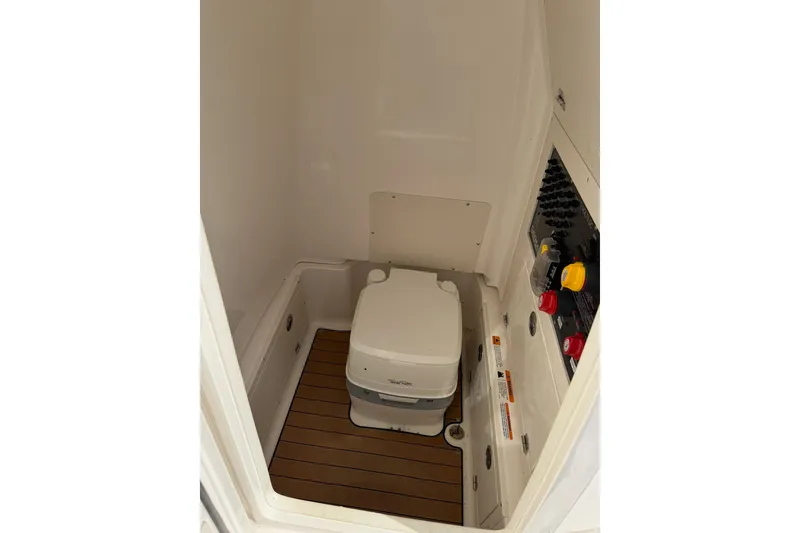 Slide: The Image of 2021 Caymas 28 HB boat interior with compact marine toilet and control panel. - 15