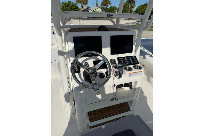 Slide: The Image of 2021 Caymas 28 HB boat console with steering wheel, dual screens, and control panel. - 1