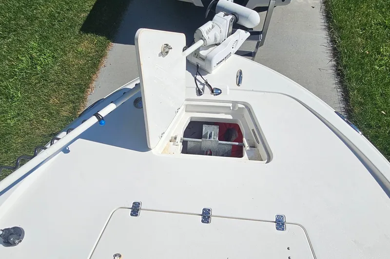Slide: The Image of The image shows the bow deck of a 2021 Caymas 28 HB boat with an open storage compartment. - 11