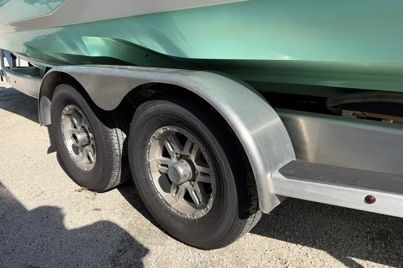 Slide: The Image of Trailer wheels of a 2021 Caymas 28 HB boat on pavement. - 34